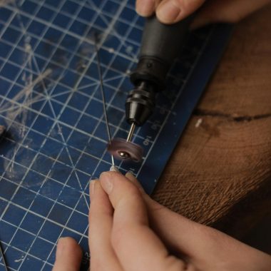Hands of a Person Holding a Tool and a Grinder