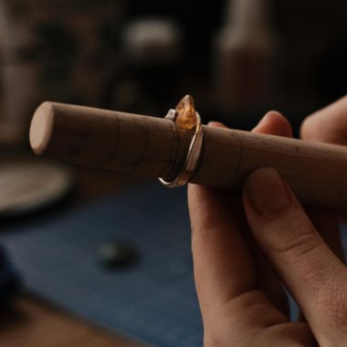 Person Holding Wooden Tool With a Silver Ring